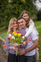 Happy family hugging in park, smiling and enjoying time together. photo