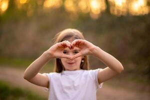 cute girl showing a heart with her hands photo