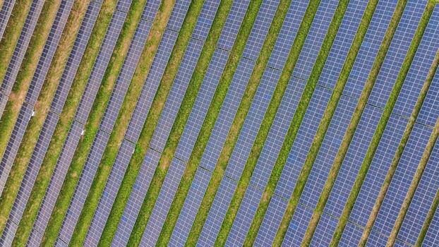 Direct aerial view of solar panel rows on green background photo