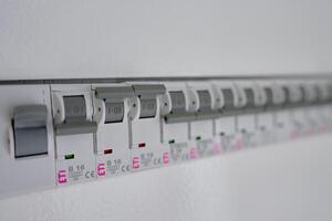 Electrical panel with row of circuit breakers in fuse box photo