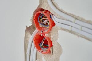 Electrical wiring installation with exposed wires and wall sockets photo