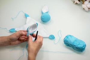 knitted toy bunny in the process of making with your own hands photo