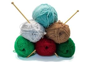 colored skeins of woolen threads and wooden knitting needles. Accessories for needlework on a white background photo