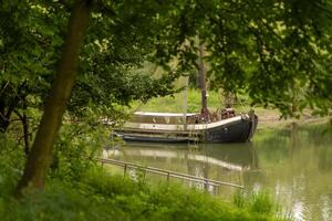 Calm river scene with a moored boat surrounded by lush greenery photo