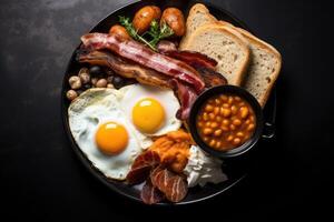 English breakfast on a plate with scrambled eggs, sausages, bacon, beans, toast and coffee on a dark stone background. photo