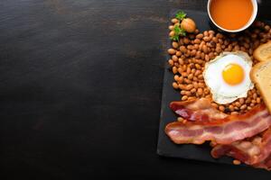 English breakfast on a plate with scrambled eggs, sausages, bacon, beans, toast and coffee on a dark stone background. photo