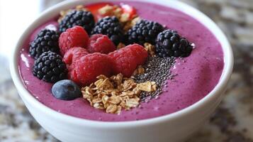Colorful smoothie bowl topped with fresh berries and granola on a textured surface in a bright kitchen photo