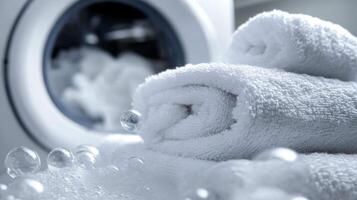 Freshly laundered white towels placed beside a washing machine in a bright laundry room during the day photo