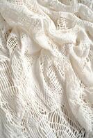 Elegant white lace fabric draping softly on a surface with intricate patterns and textures in natural light photo