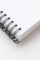 Blank spiral notebook resting on a flat surface ready for notes or sketches photo