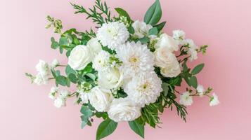 White floral arrangement with roses and dahlias on pastel pink background during daytime photo