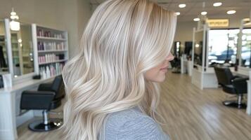 Stunning long blonde hair styled with soft waves in a modern salon setting during the daytime photo
