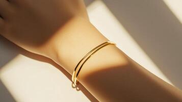 Elegant gold bangle resting on a wrist, illuminated by soft sunlight, showcasing a minimalist design and luxury craftsmanship photo