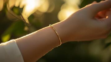 Elegant golden bracelet shines on a wrist amidst a natural backdrop during golden hour photo