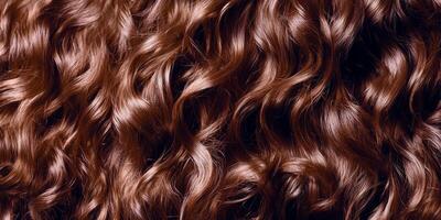 Curly brown hair with rich texture and sheen displayed in close-up under soft lighting photo