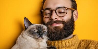 Man enjoys peaceful moment with cat against bright yellow background in cozy indoor setting photo