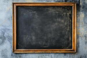 Empty chalkboard framed in wood against a textured wall ready for new lessons or creative ideas photo