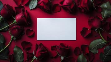 Arrangement of red roses with empty card on a red background for celebration or romantic occasion photo