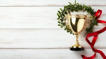 Golden trophy adorned with a laurel wreath and red ribbon on a wooden background, symbolizing achievement and success, award concept photo