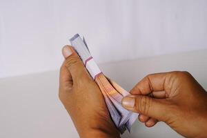 Hands meticulously counting bundle currency notes isolated white background photo