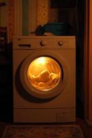 Washing machine with illuminated drum showcasing clothes in a cozy laundry room setting, emphasizing home appliance functionality and convenience concept photo