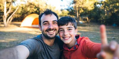Joyful father and son enjoy camping adventure while taking a cheerful selfie together in nature photo