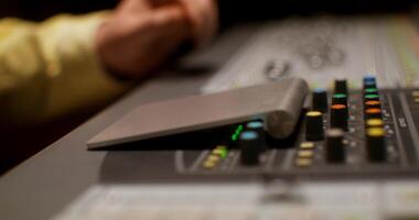 A person is using a mixer in a recording studio photo