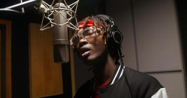 A man with dreads singing into a microphone photo