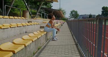 A woman sitting on a bench in a stadium photo