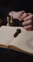 A man is studying to play chess alone, using a textbook photo