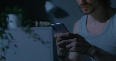 A man in a tank top is using his phone photo