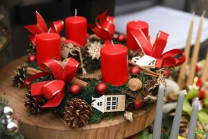 Advent wreath with red candle decorated with red balls, pine cones, cinnamon,walnuts. photo