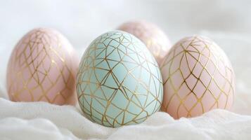 Colorful pastel Easter eggs with gold geometric patterns arranged on a soft white background for spring celebrations photo