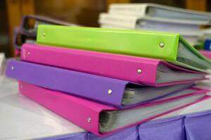 Stacks of colorful files are stacked on the desk. soft and selective focus. photo