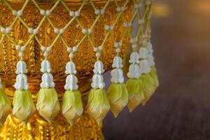 Uba is a flower that is strung in a string and attached to a bunch like a tassel for hanging on a tray with a pedestal or a flower garland photo