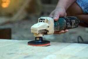 Carpenters use a sander to sand the surface of the wood to smooth the woodwork before painting. photo
