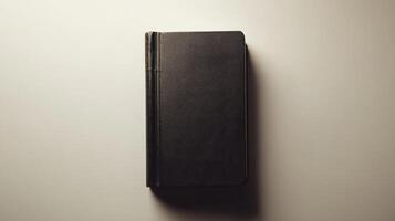 Simple black notebook resting on a flat surface highlighting its minimalistic design and sturdy spine photo