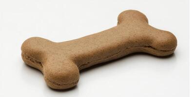 Dog biscuit shaped like a bone on a clean white surface suitable for pet treats or snacks photo