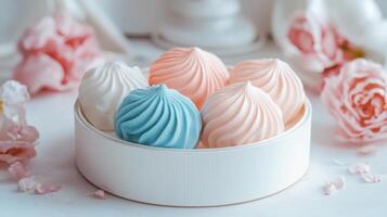 Delicate pastel meringues arranged in a stylish container surrounded by fresh flowers photo