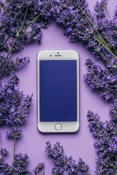 Smartphone surrounded by lavender flowers on a purple background creating a calming and aesthetic arrangement with natural elements photo