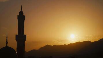 Sunset over a mosque and mountains creating a serene atmosphere in the evening sky photo