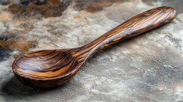 Handcrafted wooden spoon featuring intricate grain patterns rests on a textured surface in a kitchen setting photo