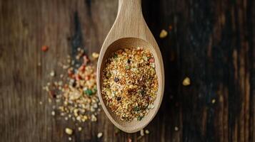 Colorful spice blend in a wooden spoon on a rustic wooden surface during daylight photo