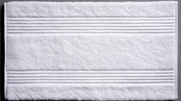 Soft white bath towel with textured stripes on a clean surface ready for use after a relaxing bath or shower photo