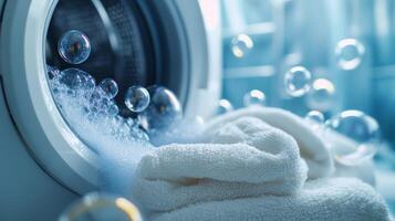 Bubbles emerge from a washing machine as freshly laundered towels await drying in a bright laundry room photo