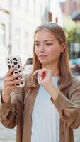 Young woman using smartphone scrolling typing text messages in mobile navigator app on street video