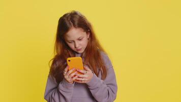 Preteen child girl kid using mobile smartphone typing new post on web, sms message, watching video
