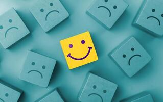 Mind, Mental Health Concept.Varieties of Mood and Emotion. a Unique Smiling Cube that Stand Out among Crowd photo