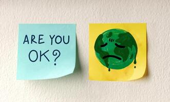World Earth Day Concept. a Message on Sticky Note represent Caring and Encouraging the Tired Green Globe. photo