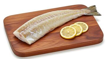 Fresh Raw Cod Fillet with Lemon Slices on Wooden Cutting Board photo